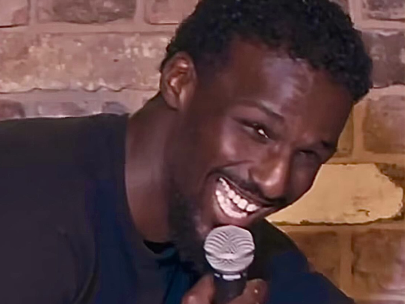 Close up of a man with microphone smiling at the camera