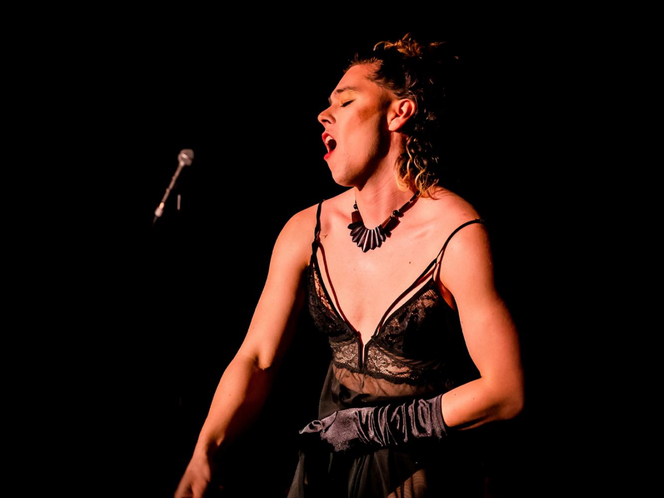 Neo-Burlesque performer throwing their glove suggestively  to the crowd.