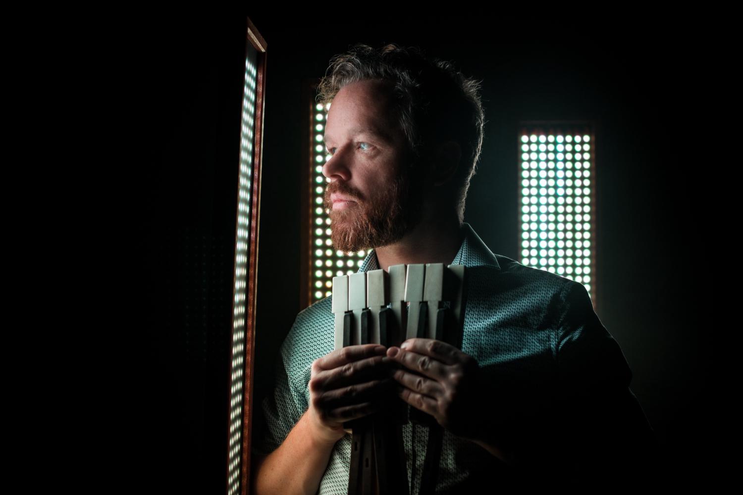 Larkhall holds piano keys in front of a tower of lights