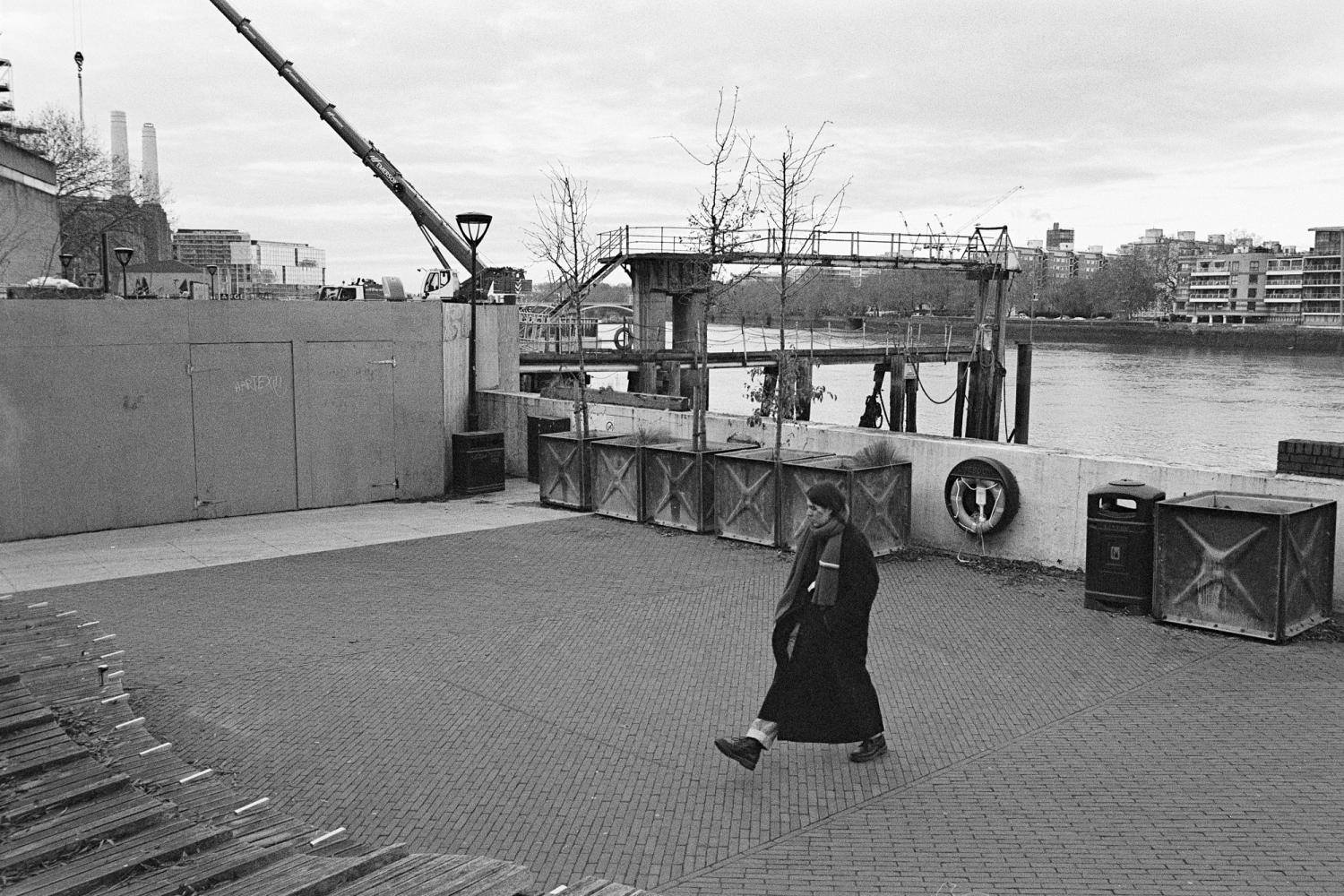 A photograph of the Thames Walk in Nine Elms. The performer is walking to trace a small square.